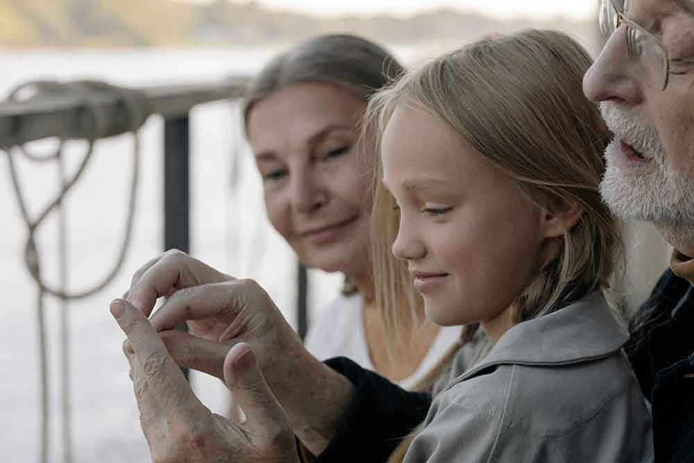 Close up of an older person holding hands with a younger person